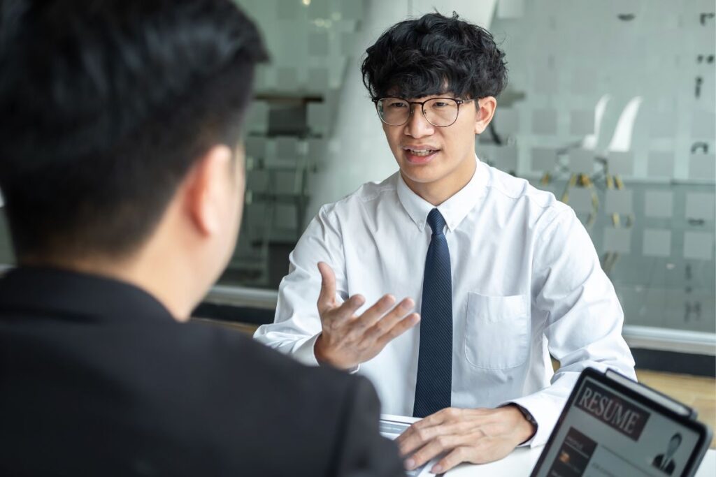 Candidato apresentando suas qualificações em entrevista de emprego com currículo digital ao fundo