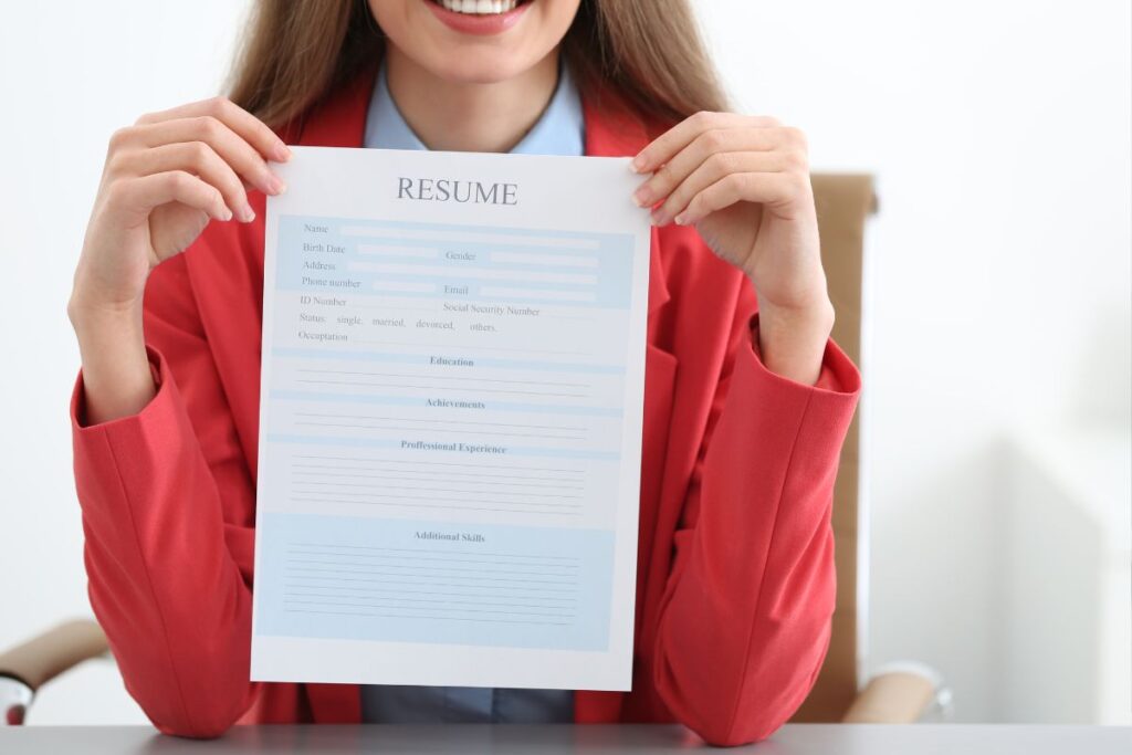 Mulher sorridente segurando currículo profissional em destaque, pronta para entrevista de emprego