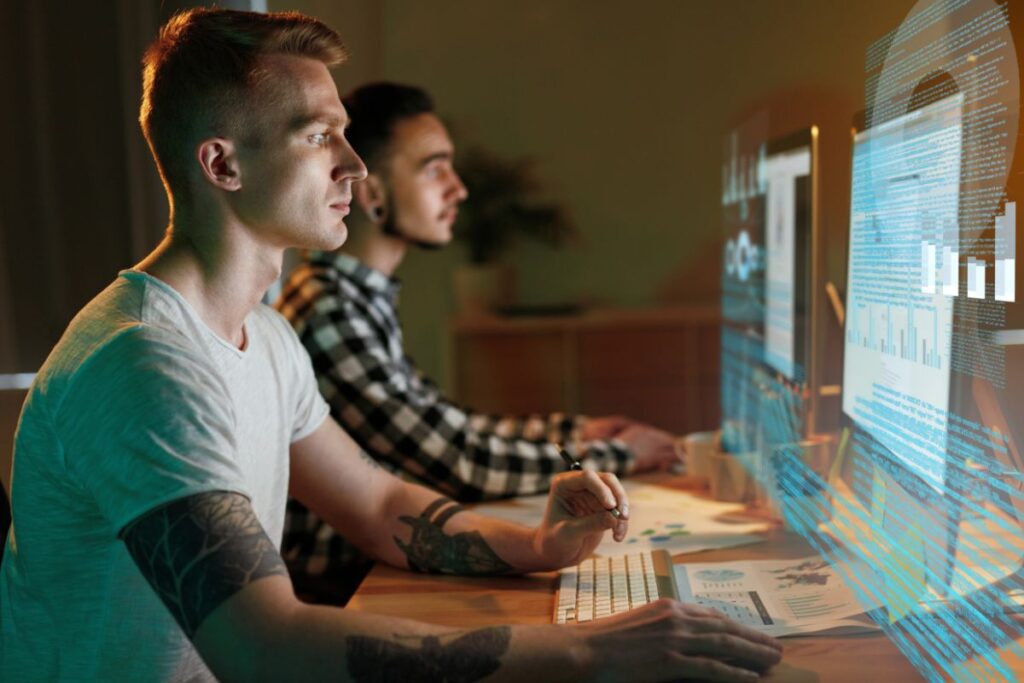 Dois desenvolvedores de software em home office trabalhando em código e análise.