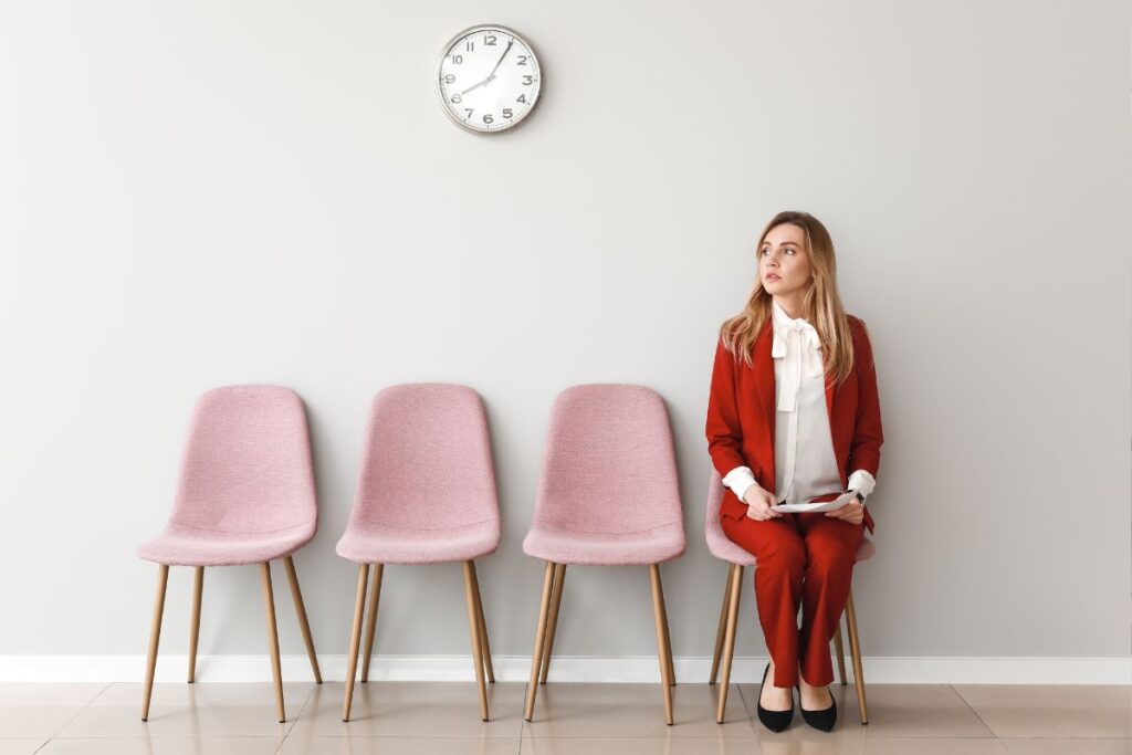 Mulher aguardando ansiosamente por uma entrevista de emprego em uma sala de espera.