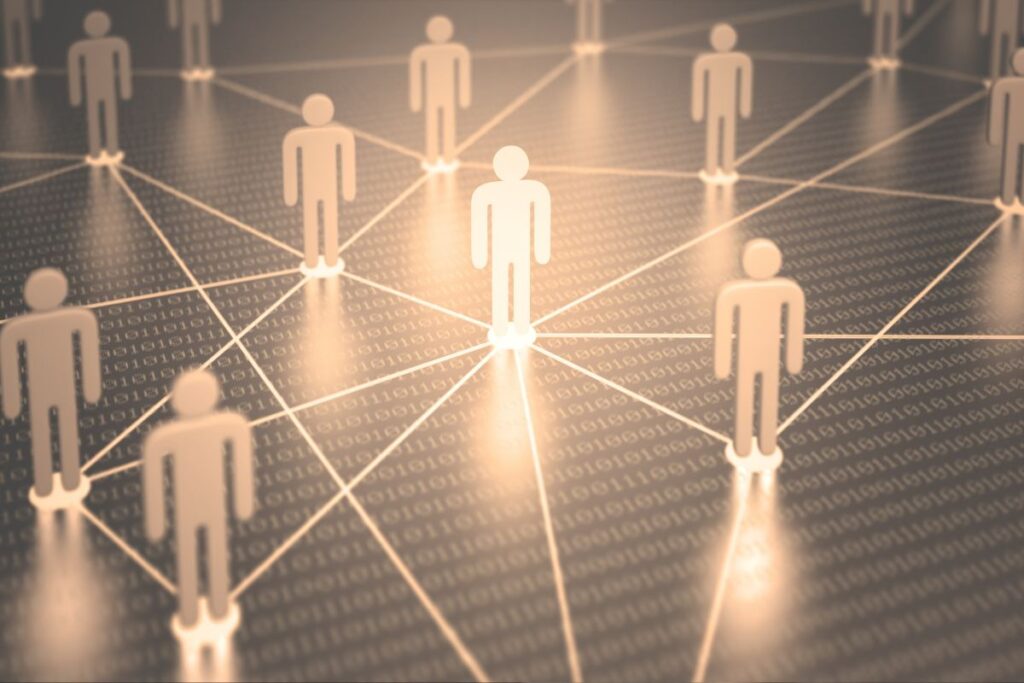 Uma figura central iluminada em uma rede de ícones de pessoas conectadas, representando o foco no indivíduo dentro de uma rede de contatos.
